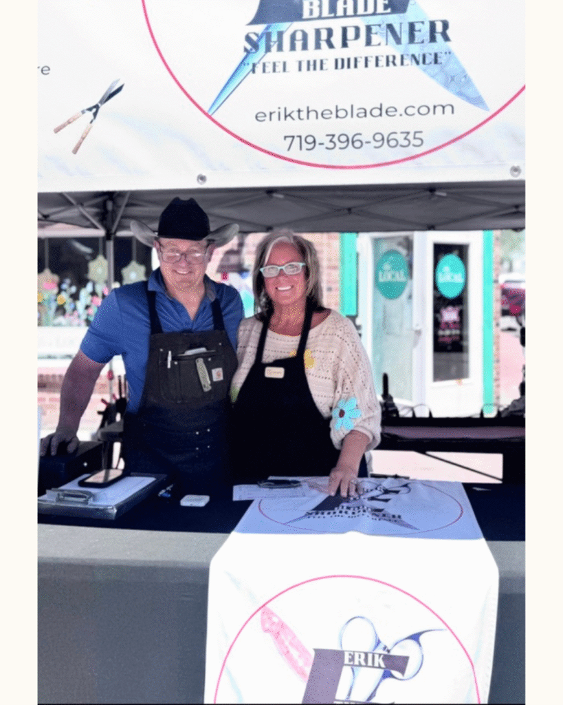 Erik and Beverly standing under the Erik the Blade sharpening tent at the Parker Farmers Market.