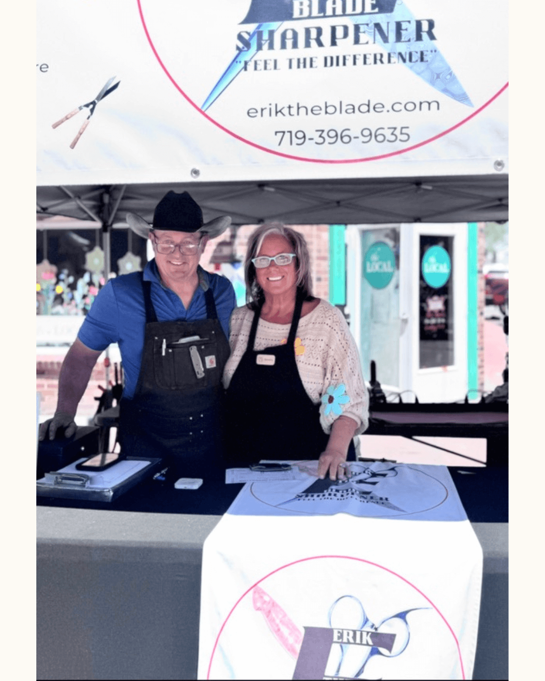 Erik and Beverly standing under the Erik the Blade sharpening tent at the Parker Farmers Market.